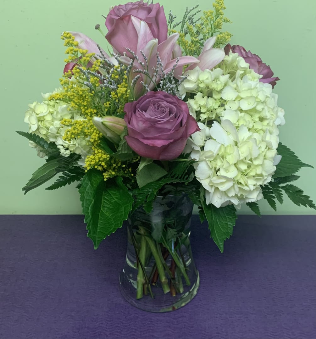 This beautiful arrangement is full of Roses, Hydrangeas, Lilies, Aster, and Limonium.