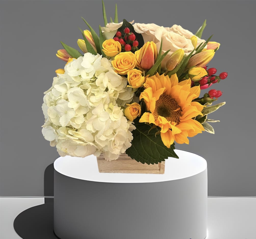 A sweet mix of hydrangea, sunflower, roses, tulips and berries in a