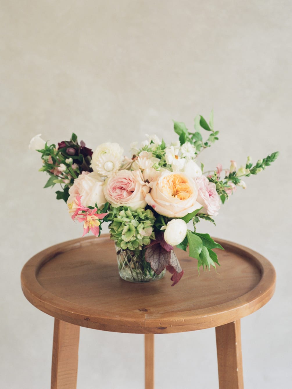 A soft and airy arrangement designed in a glass vase. In a