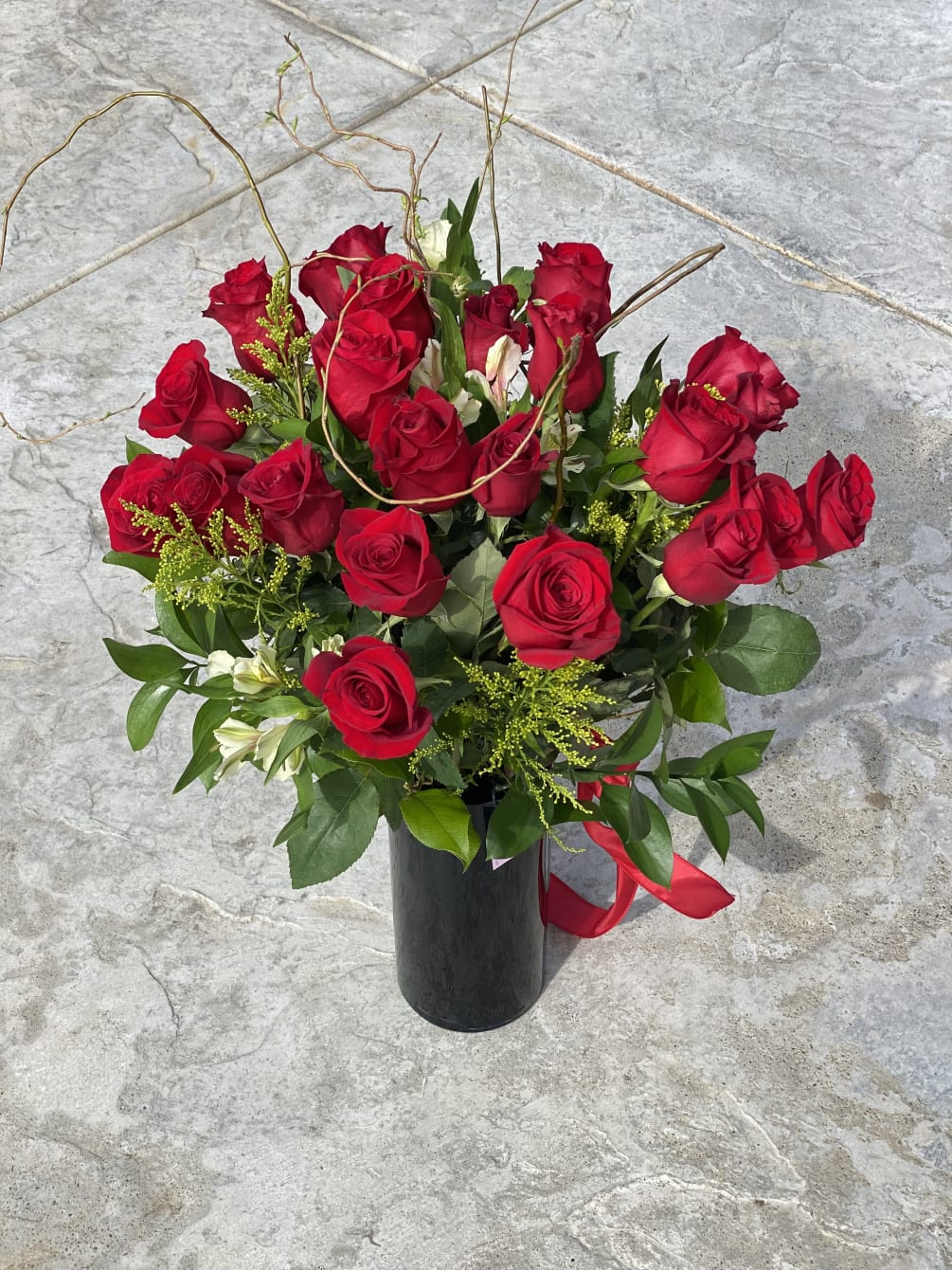 Beautiful two dozen of long stem roses in a tall glass black