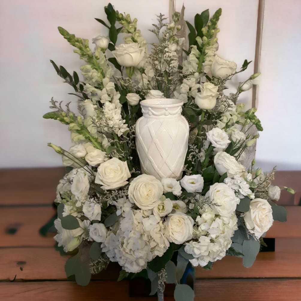 An abundance of white flowers form a classic background to an urn