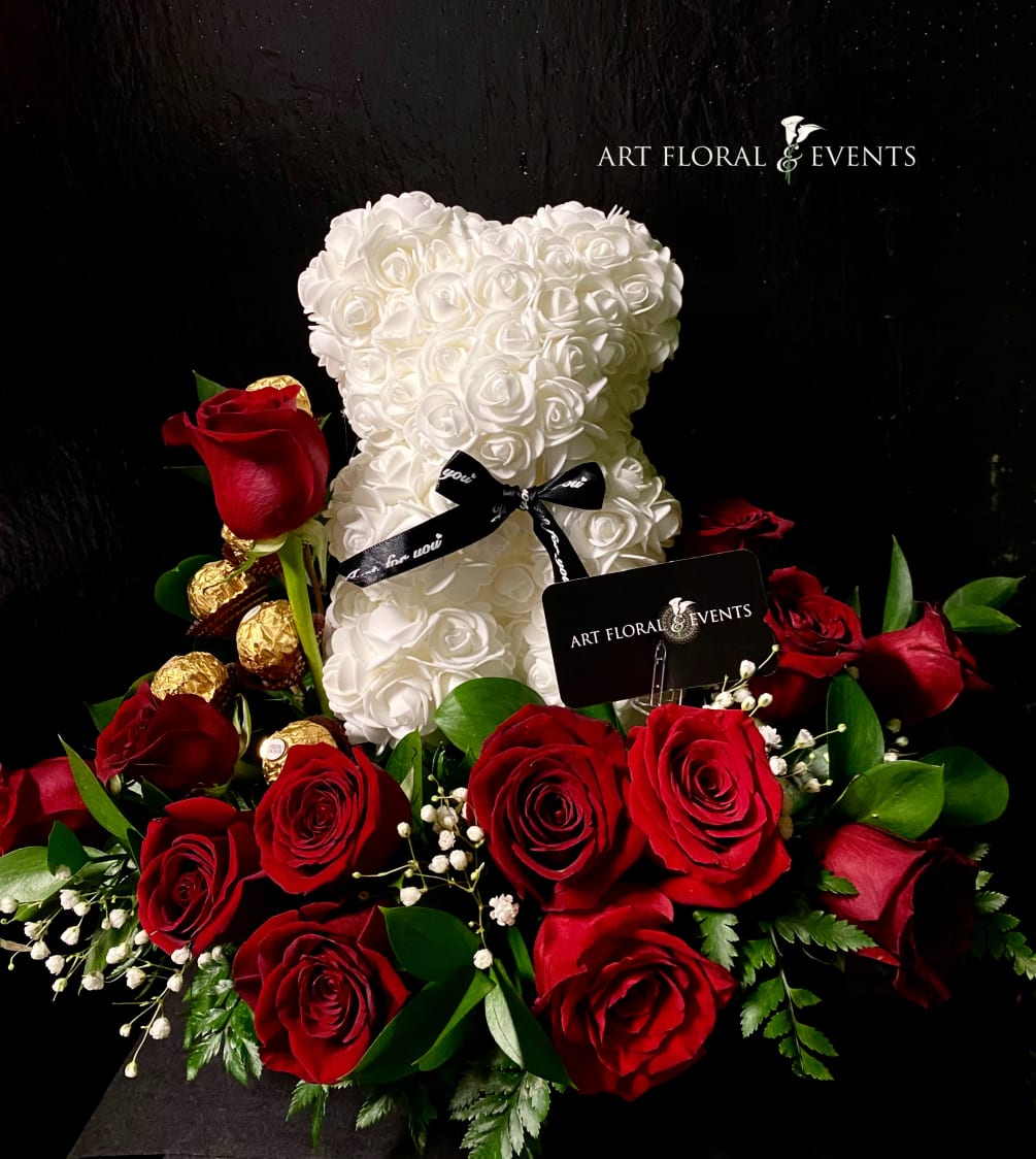 White bear embellished in artificial roses, in a bed of 24 fresh
