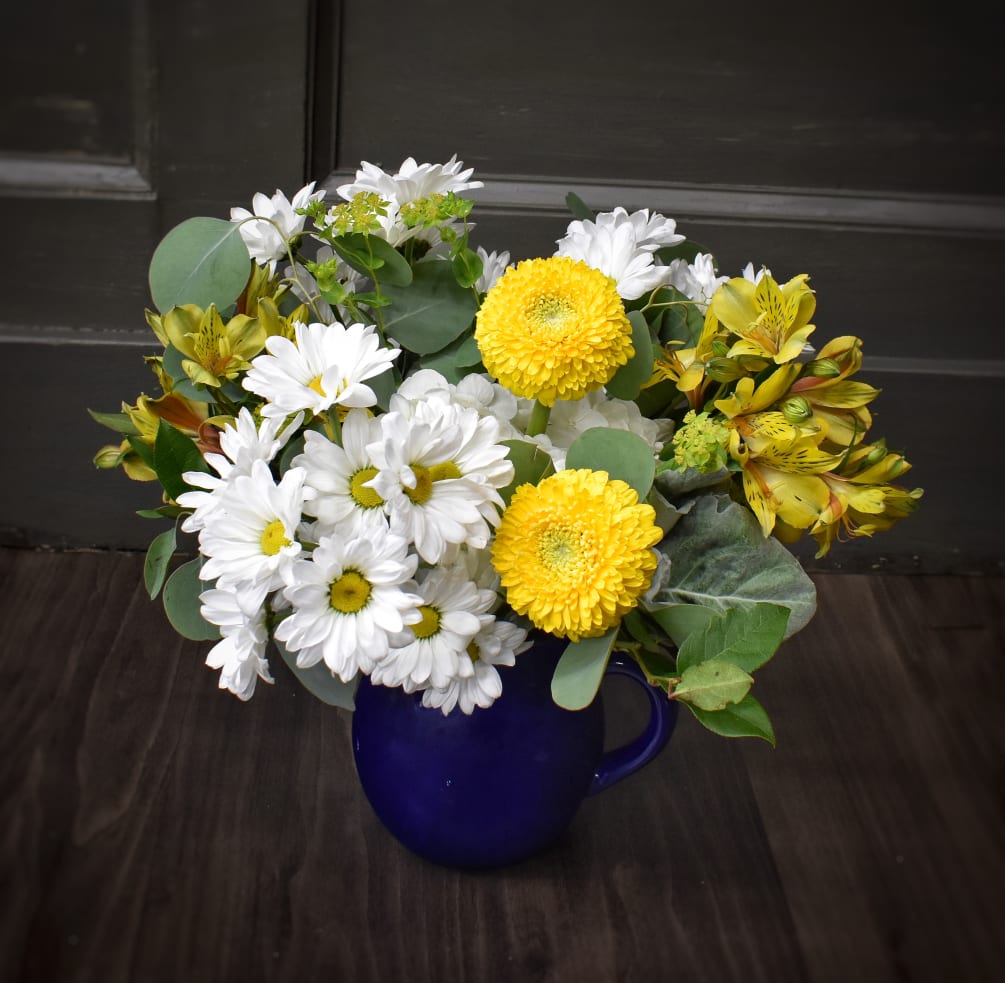 This pretty yellow bouquet comes destined a keepsake dark blue ceramic pitcher.