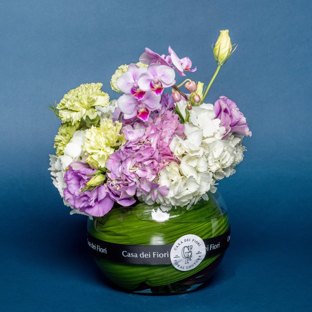 Hydrangea, carnations and purple orchids arranged in a vase.
