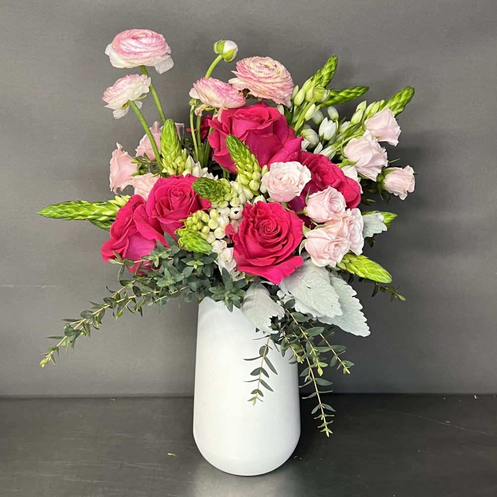 This stunning floral design has roses and seasonal flowers thats are arranged