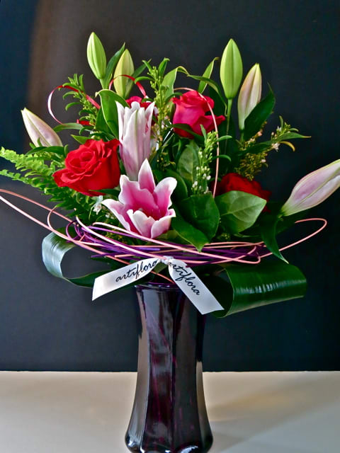 Encircled in a frame of tinted cane, this lush bouquet speaks loudly.