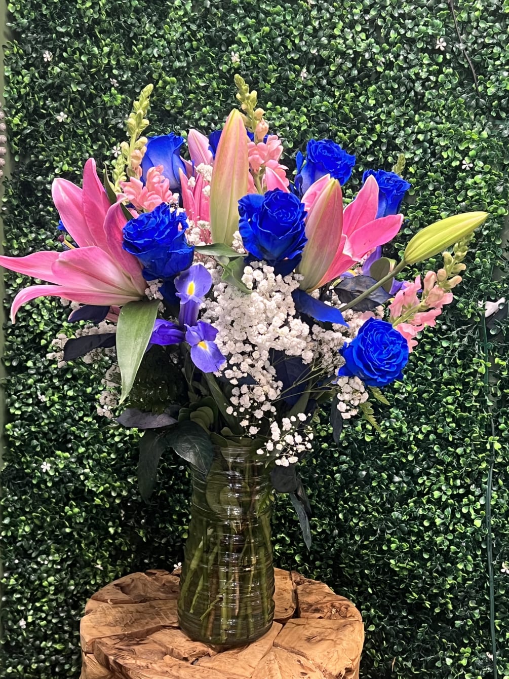 Deep blue roses, pink oriental lilies, snapdragons, and iris come together to