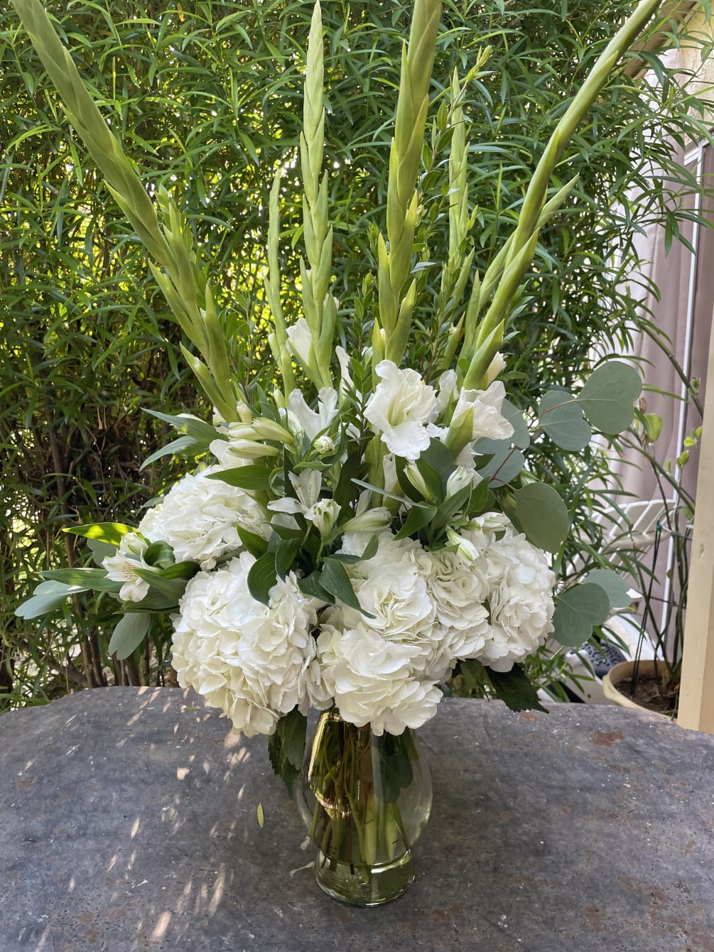 All white arrangement containing gladiolus, alstromeria and hydrangea
