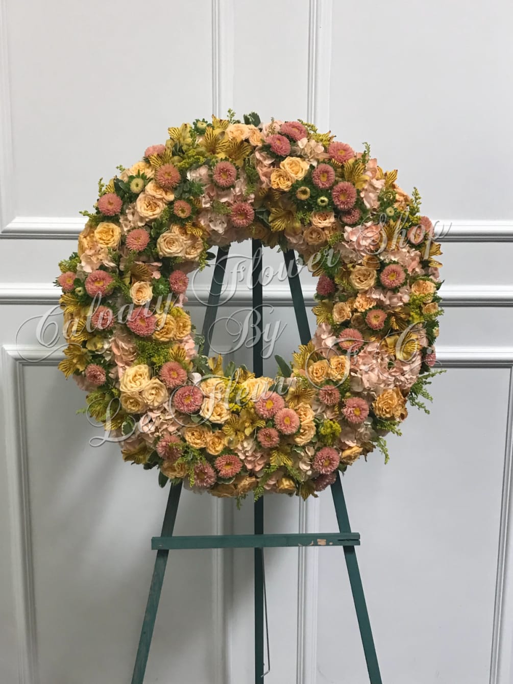 A beautiful wreath consisting of peach hydrangea, peach asters, yellow astromeria, yellow