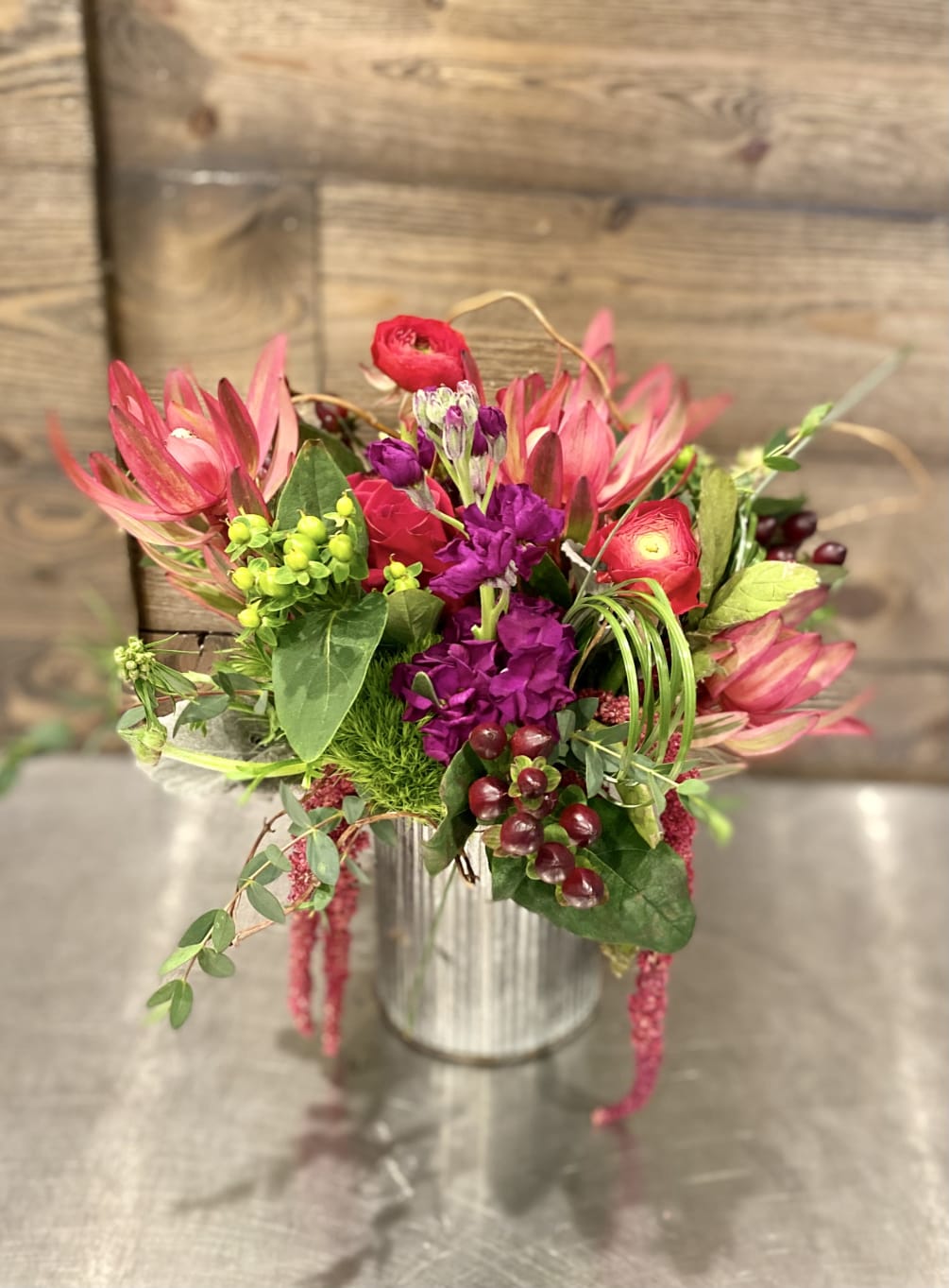 Eclectic mix of jewel toned flowers including leucadendron, hypericum, dianthus, amaranthus and
