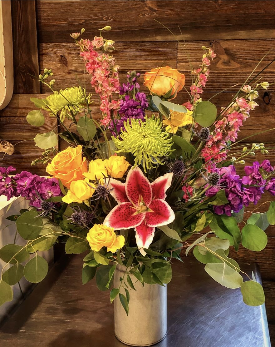 A grand display of bright and colorful flowers, including lilies, roses, mums