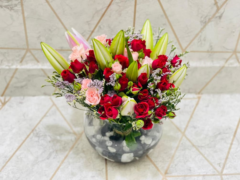 lily and red roses put in a round  base perfect for