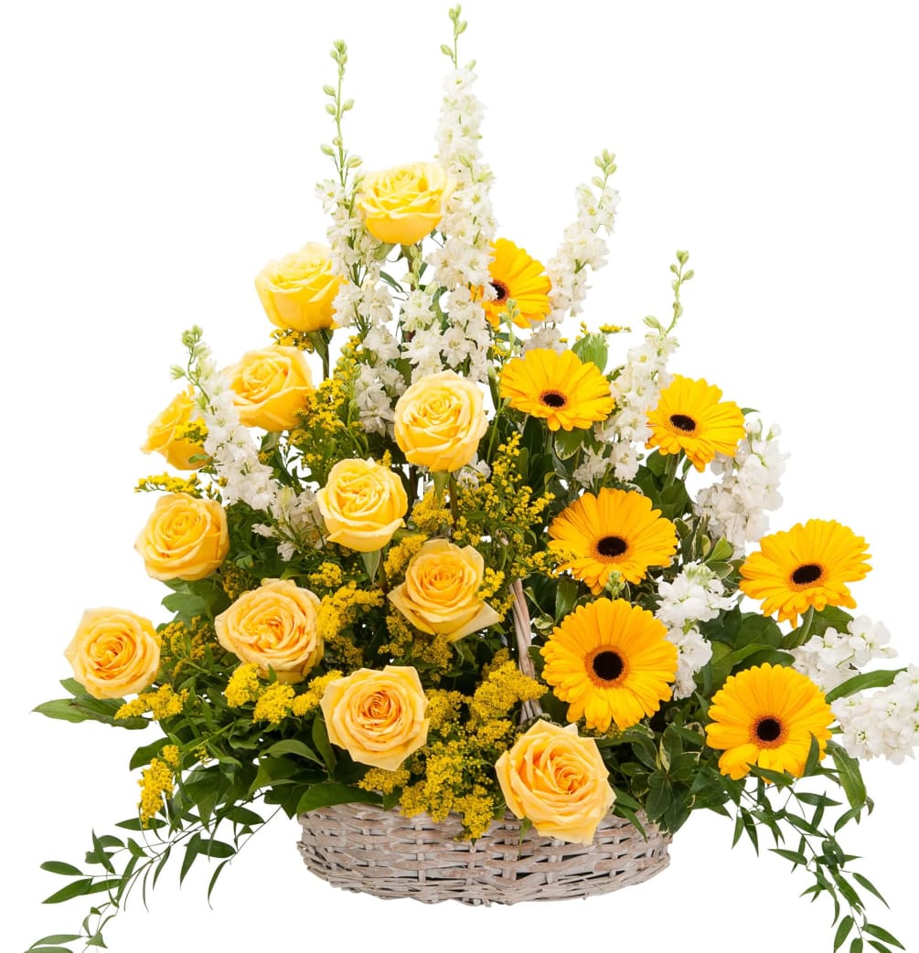 A wicker basket filled with a beautiful selection of roses, gerber daisies