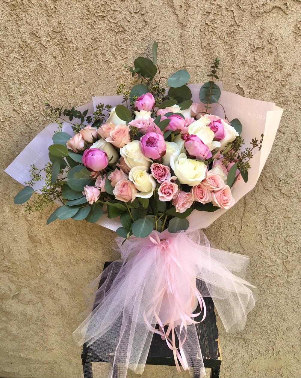 Beautiful pink and white arrangment featuring peonies (seasonal), white and pink roses
