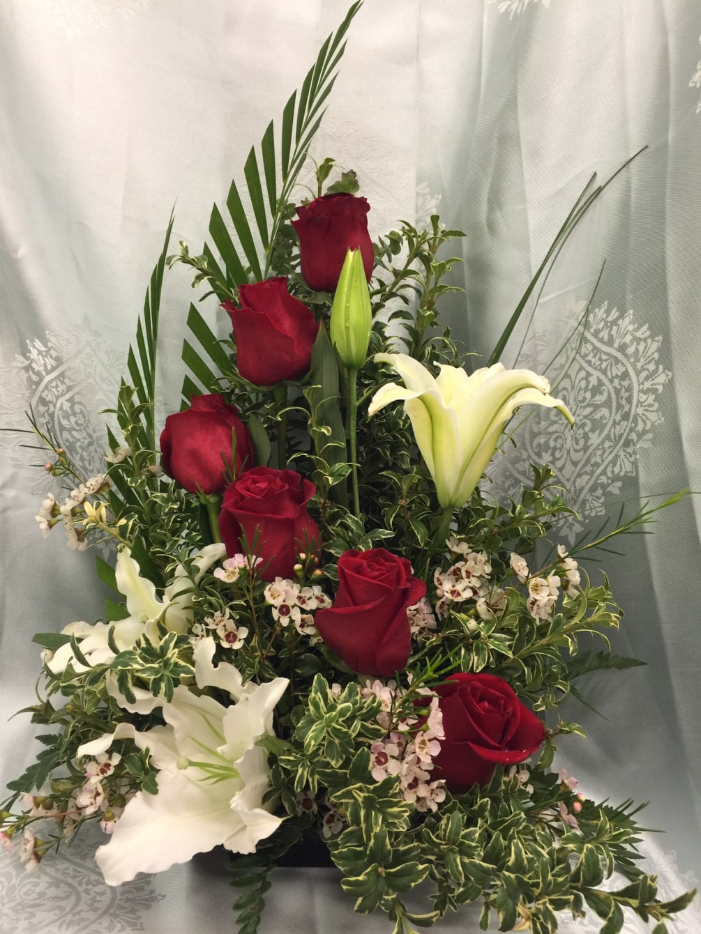 Impactful arrangement of red roses and white lilies for any occasions. 