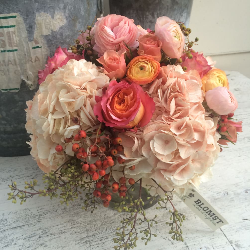 Beautiful goldren orange, peach and light pink colors in this sweet arrangement