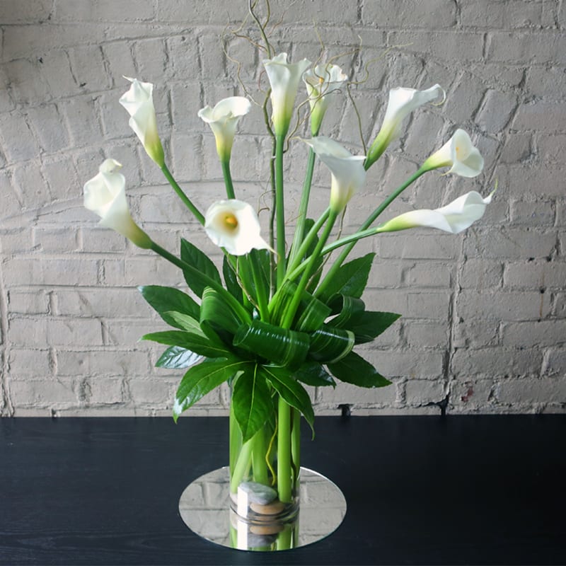 Gorgeous arrangement of large calla lilies and greens.