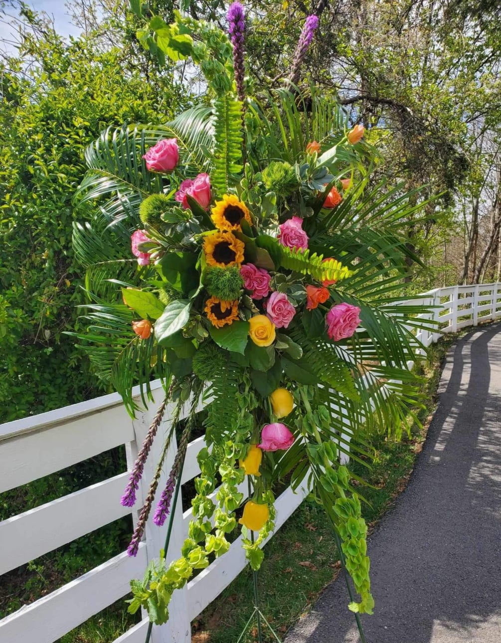 Bringing together Liatris, yellow sunflowers, orange and yellow roses, pink spray roses