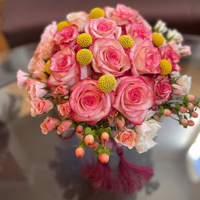 This gallant gift of yellow, orange and caramel, pink roses in a