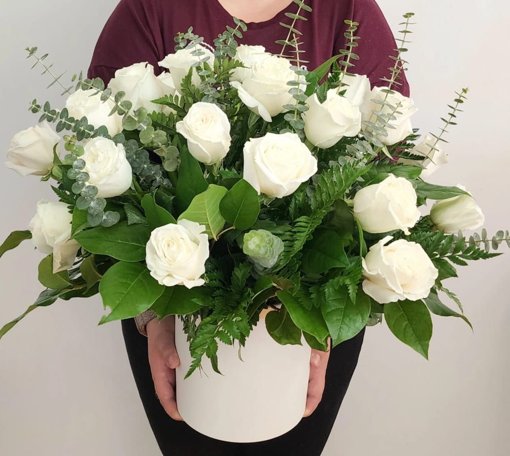 24 perfectly bloomed white roses in a white ceramic with several mixed