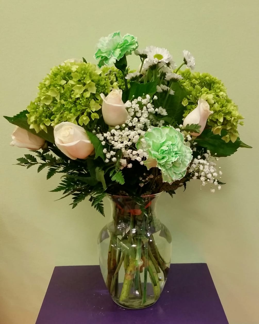 This is an elegant green and white arrangement  Include roses, hydrangeas