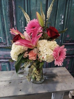 A lovely bouquet of sweet cabbage roses, lilies and gerber daisies in