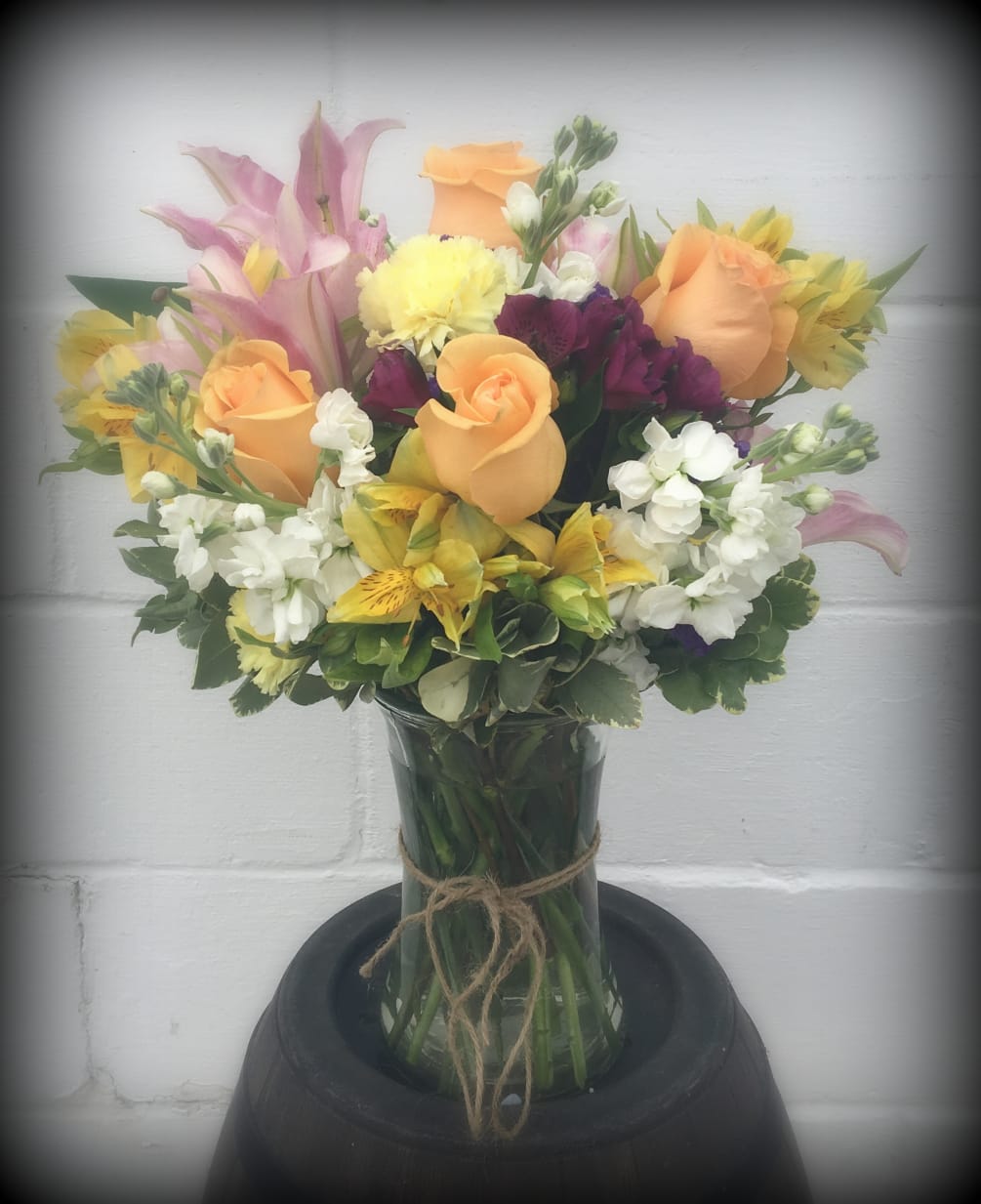 Peach Roses with mixed flowers give this vase arrangement a pretty garden