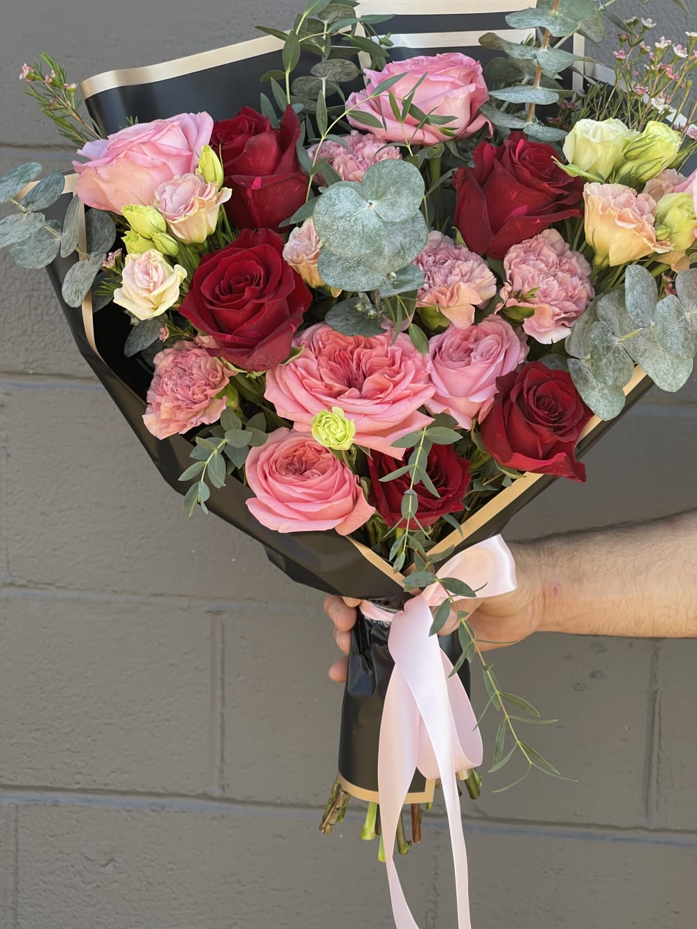This bouquet is beautiful and created with beautiful reds, pinks and shaped
