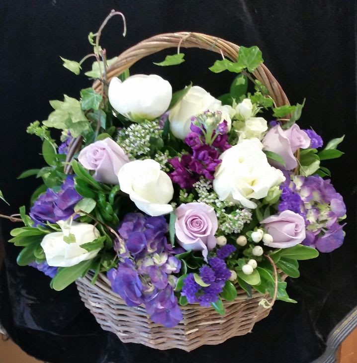 This vintage-styled natural basket is filled with lavender and white premium roses
