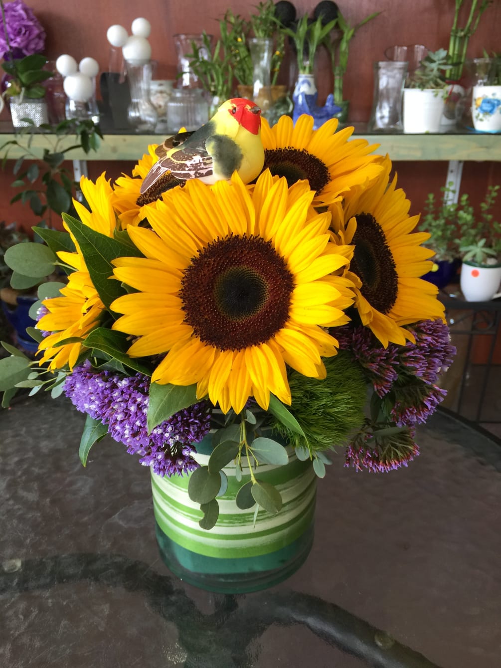 Arrangement of Sunflowers held in a short vase.