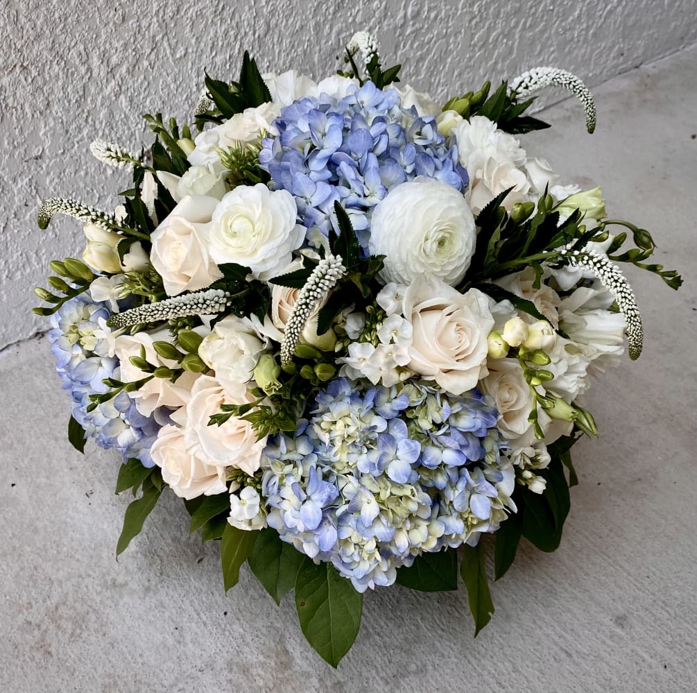 This luxury arrangement contains mixed florals such as roses, blue and white
