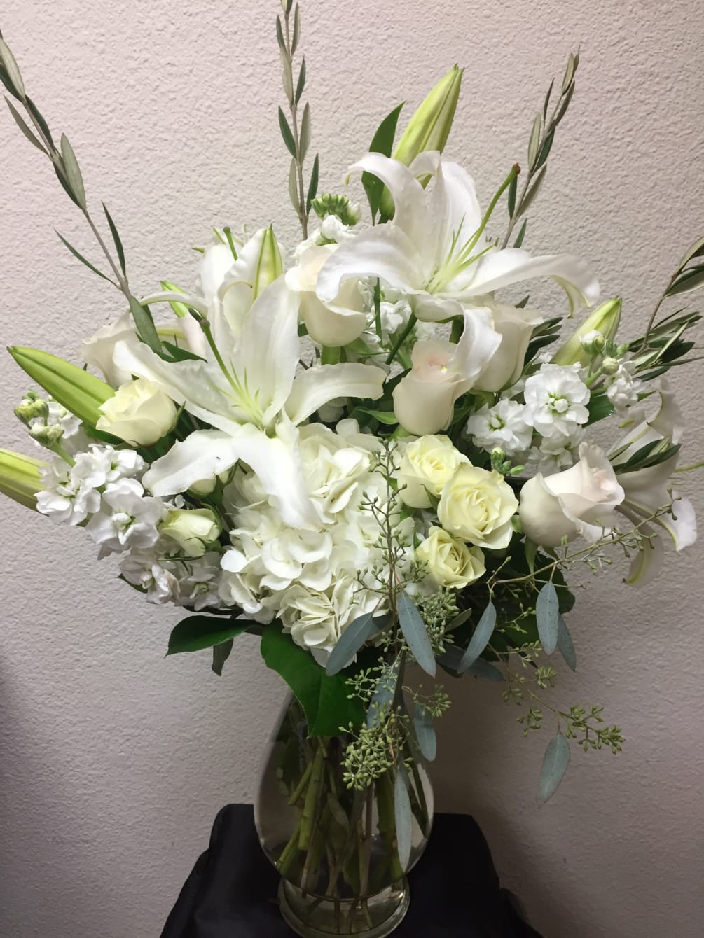 This snowy arrangement includes all-white Asiatic Lilies, Roses, Stock, Hydrangea, and Spray