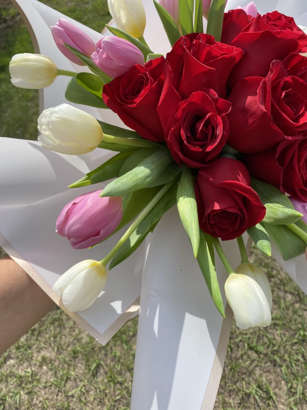Beautiful dozen red roses with white and pink tulips,wrapped.  Glass vase
