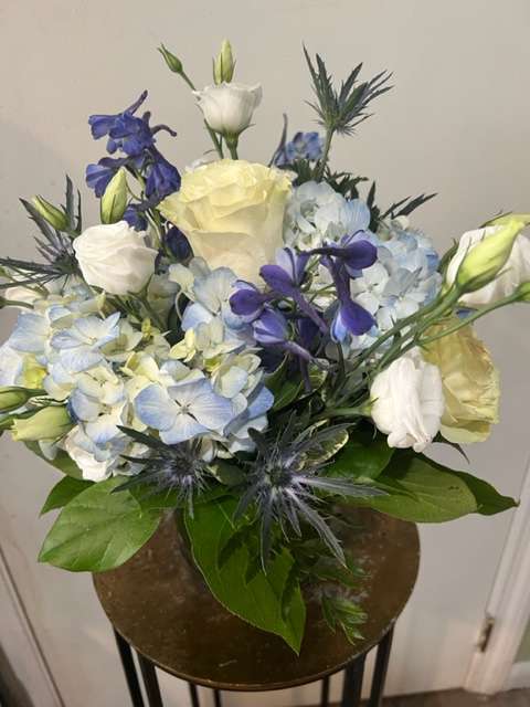 Reminiscent of a New England summer day with blue hydrangea, delphinium and