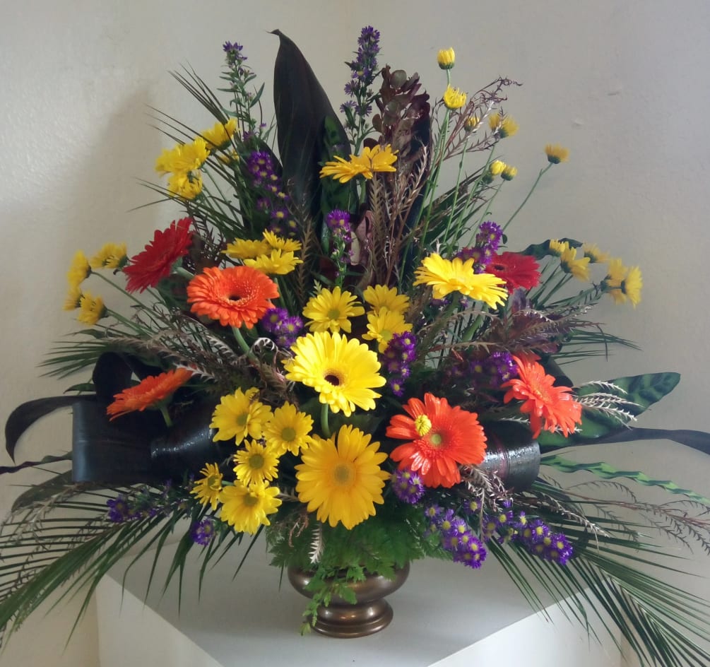 Reds, oranges, yellows and purple artfully arranged in a copper color urn