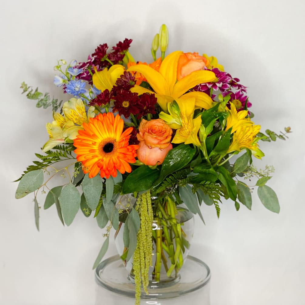 Colorful blooms of Gerbera daisies, asiatic lilies, roses, alstroemerias and delphinium accented