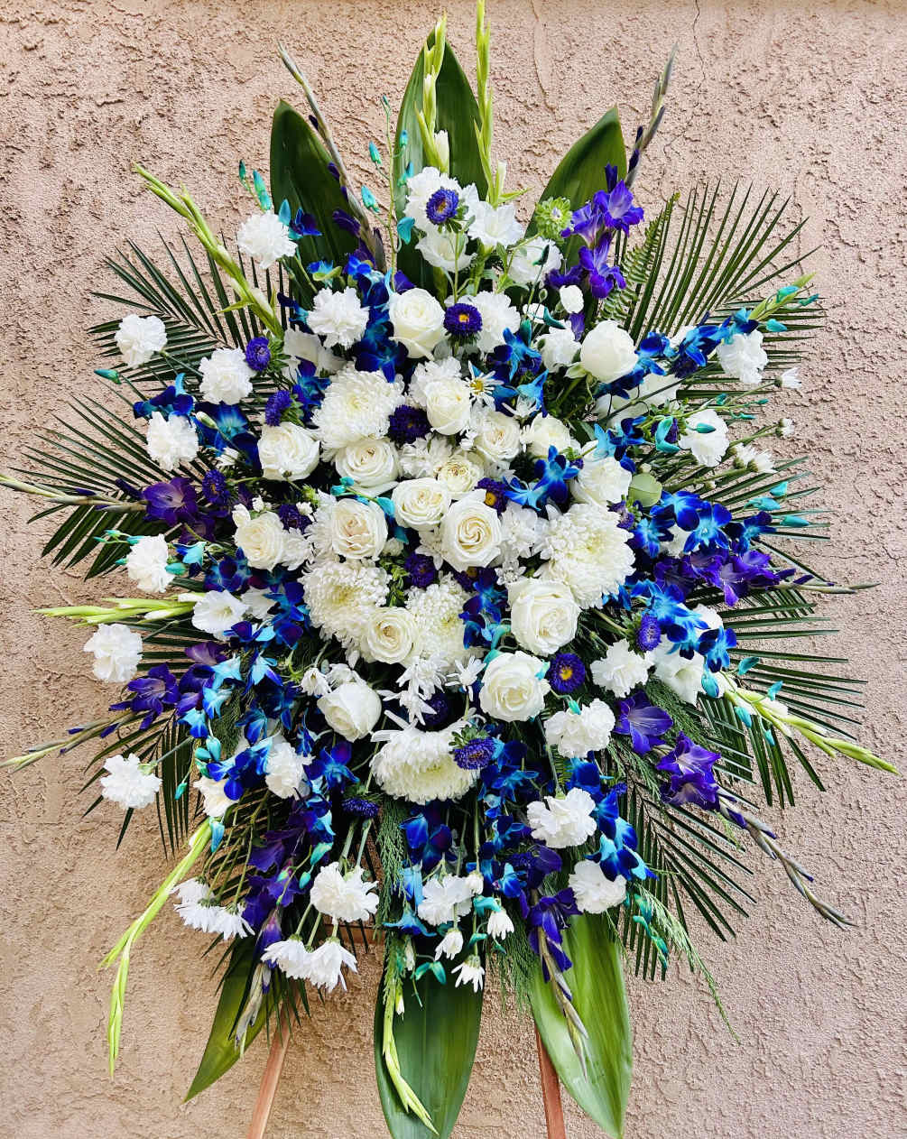 Beautiful blue and white floral spray featuring gladiolus, roses, chrysanthemum, daises, and