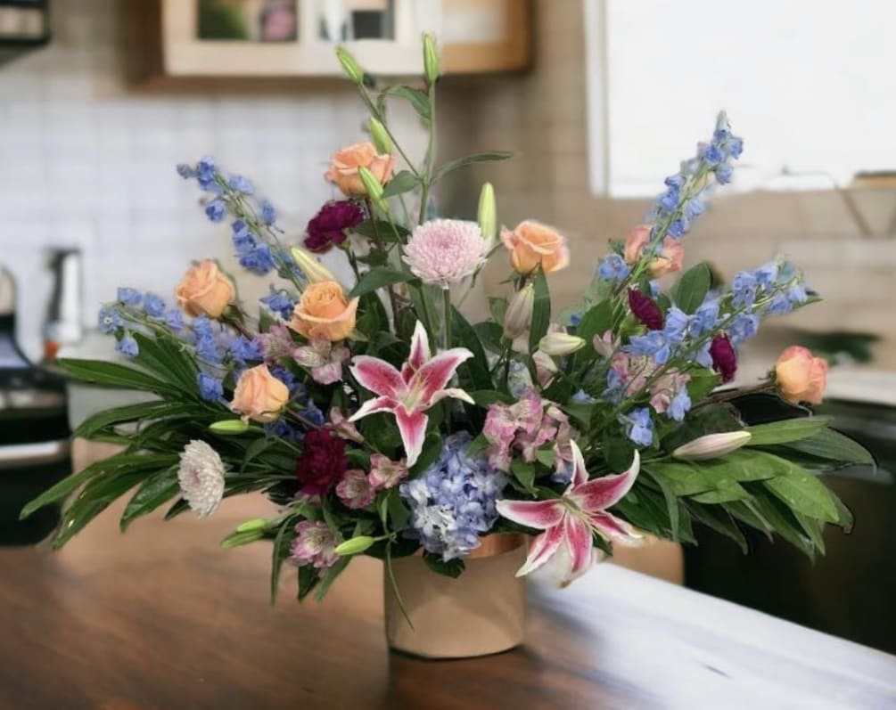 This blue and peach arrangement is anything but bashful! A large and