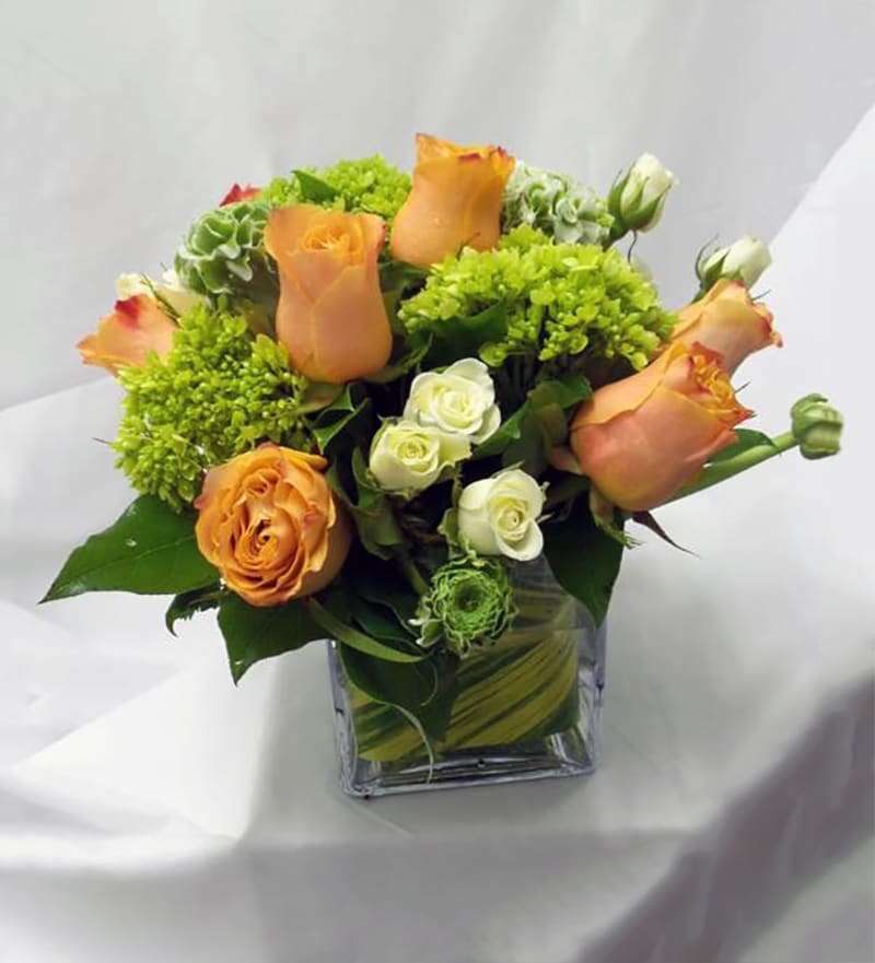 Welcome Autumn with a delightful arrangement of orange roses, white spray roses