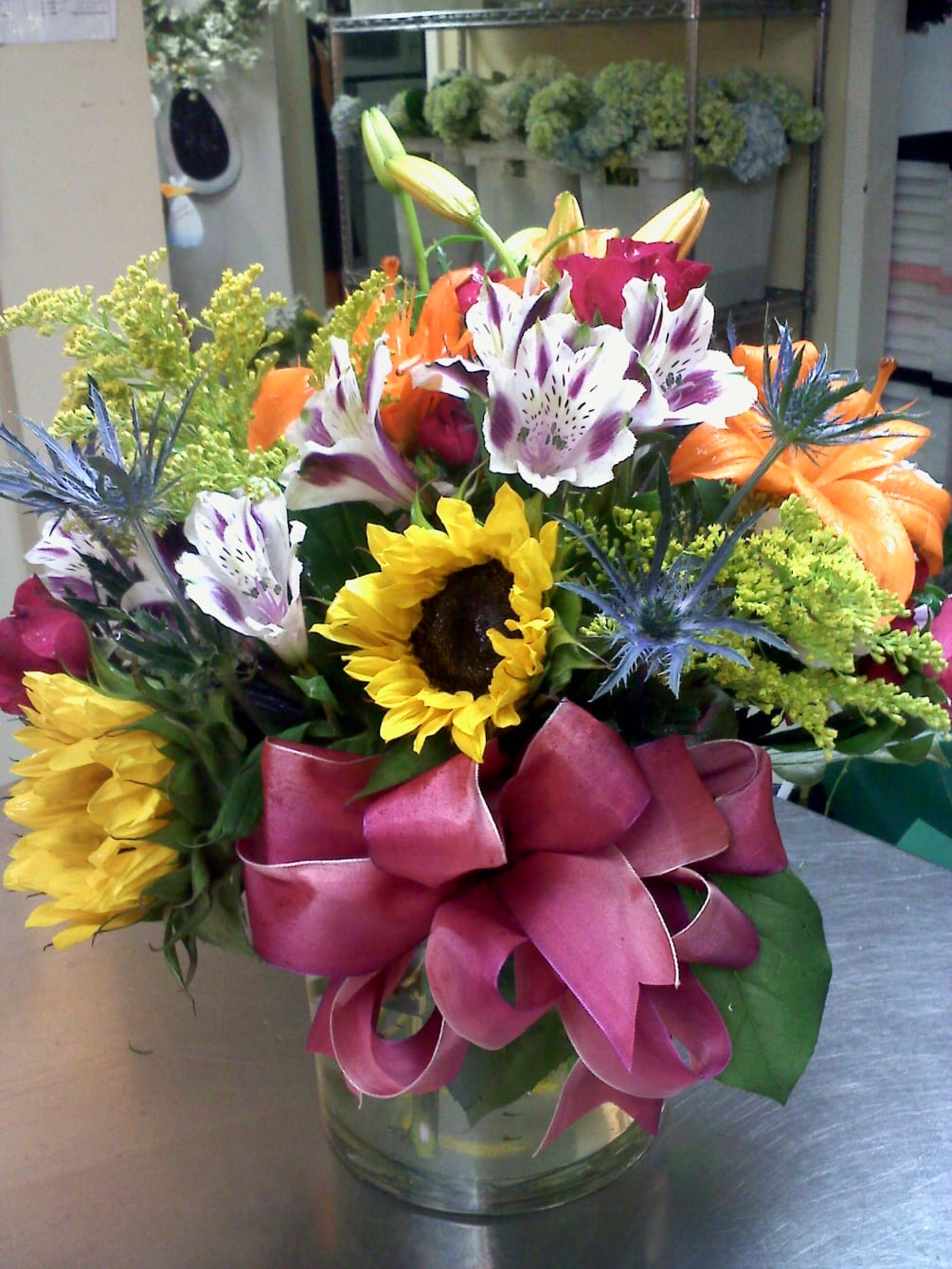 colorful mixture with sunflowers, orange lilies, and summer fillers made in a