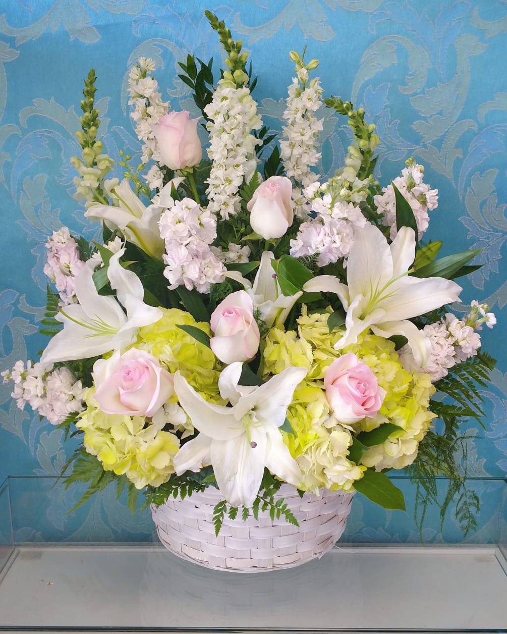 This large whicker basket is designed with soft green hydrangea, large white