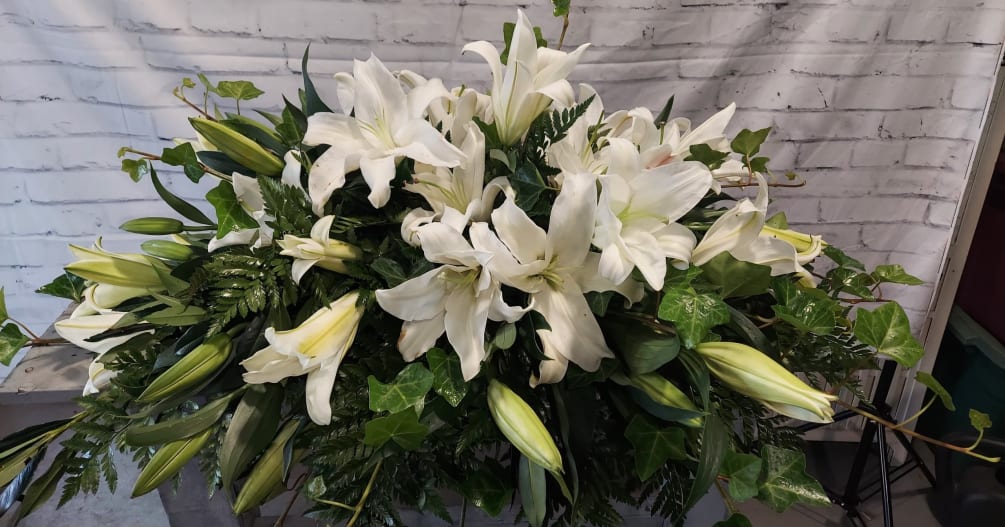 This all white lily presentation is spectacular against the dark green contrast