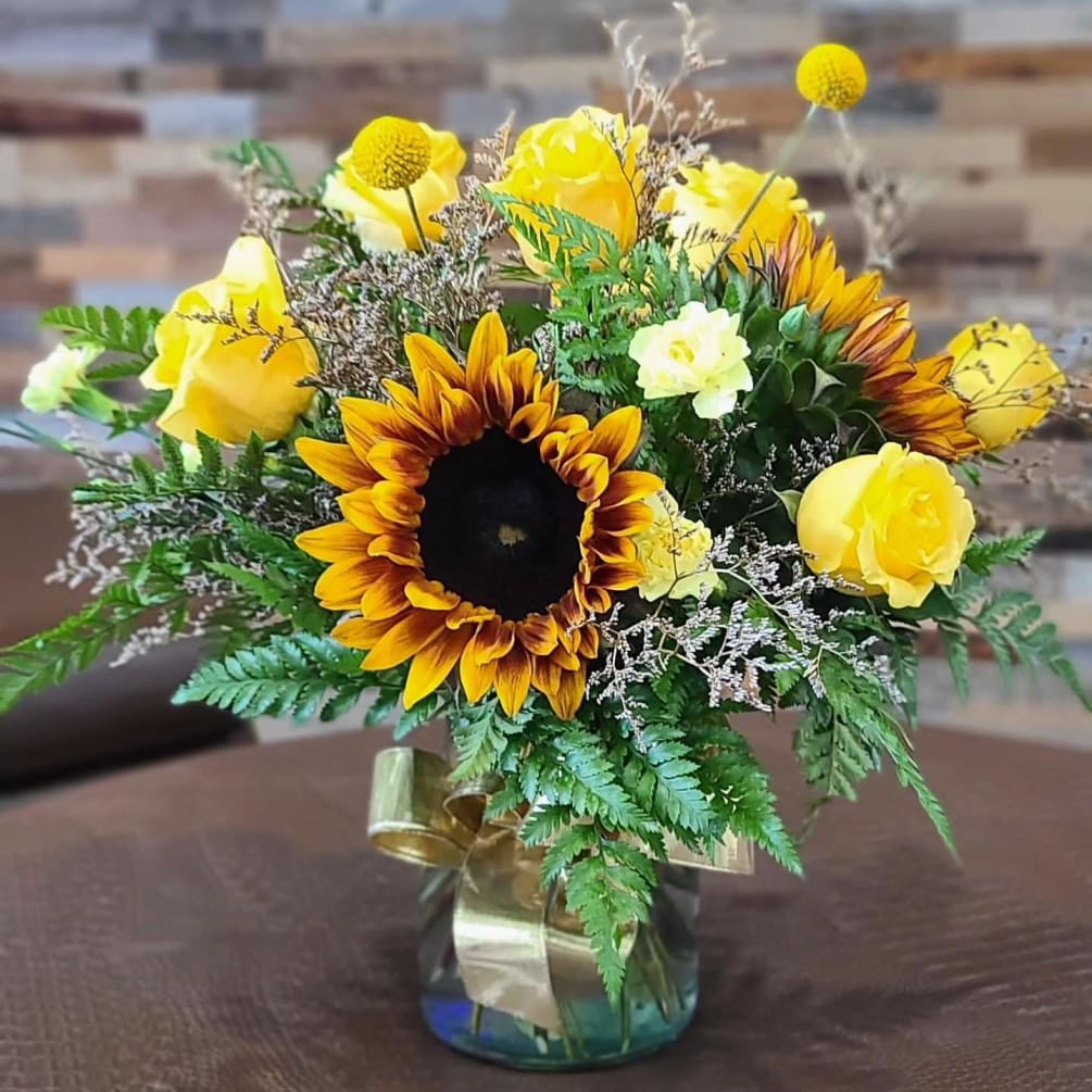 A fresh arrangement in a vase featuring fall colors, orange, red, and