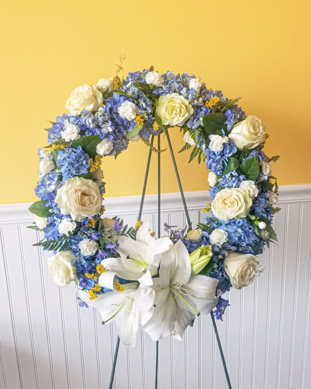 Our majestic blue and white standing spray wreath will help honor their