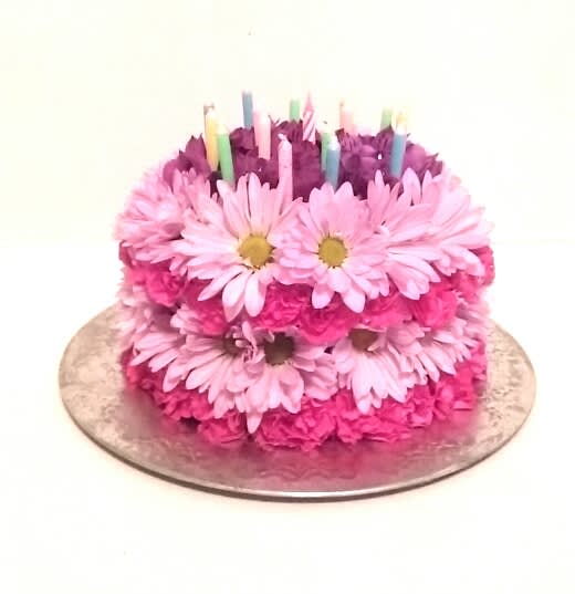 A fresh and beautiful fresh flower cake of assorted flowers and candles.