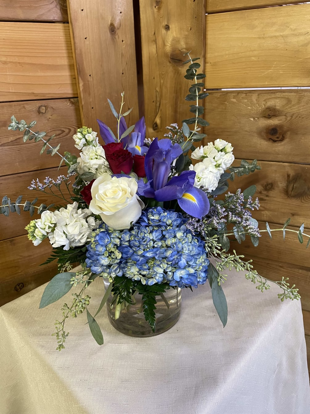 This patriotic color combination includes blue hydrangea, blue iris, white roses, white
