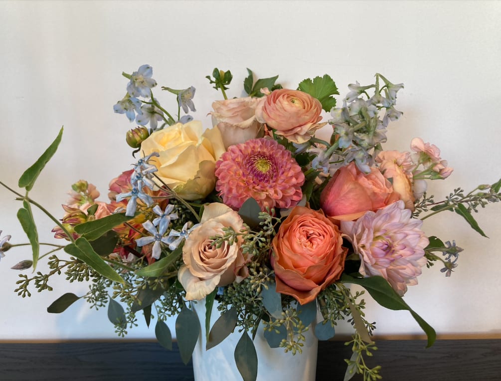 This delicate arrangement of seasonal flowers in a soft color palette is