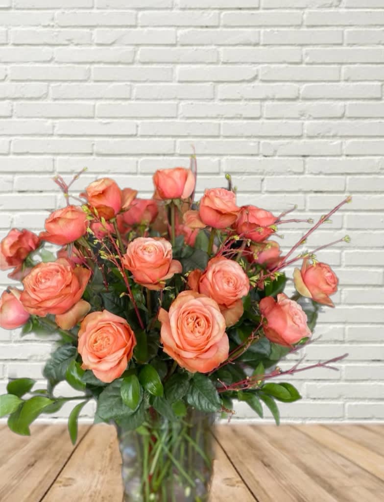 A stunning arrangement of 24 Peachy Blush Roses with local greenery and