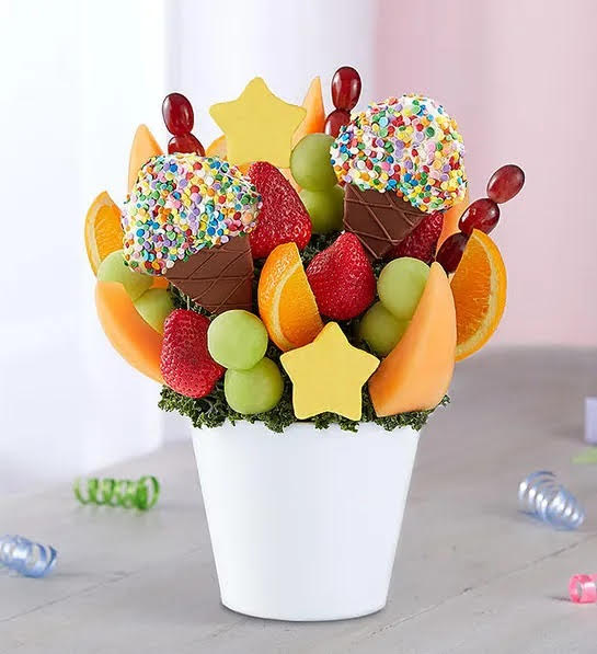 Fruit arrangement includes pineapple slices shaped like ice cream cones; dipped and