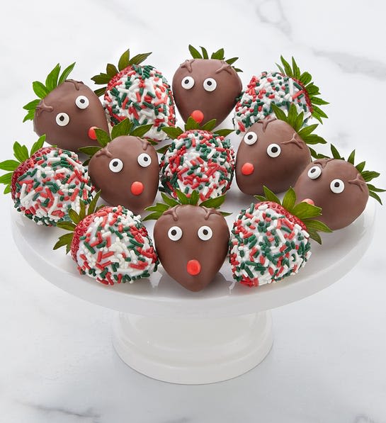 A dozen strawberries dipped in milk chocolate with reindeer faces, or dipped